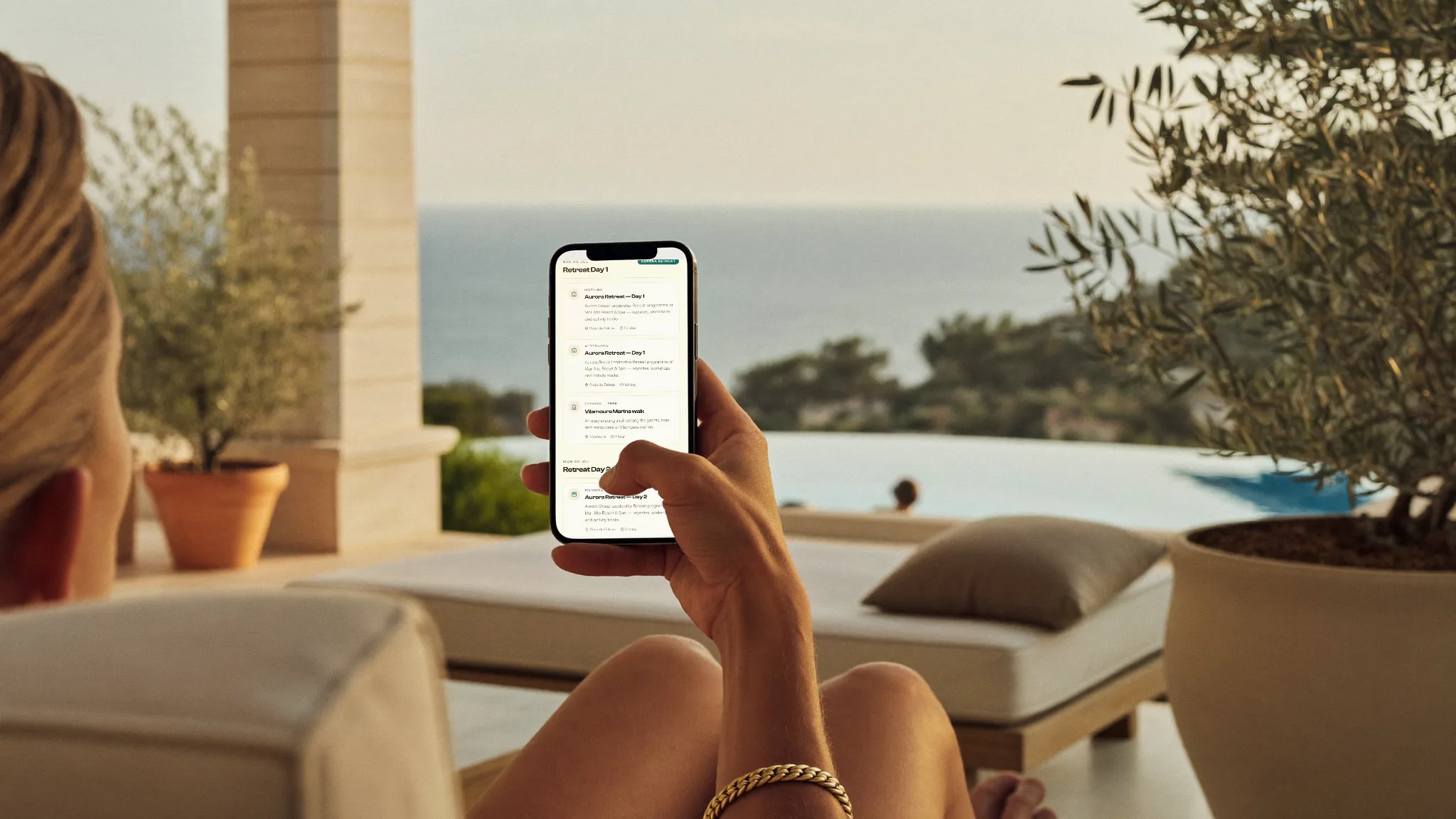 A guest on a sun-drenched resort terrace using the concierge on their phone